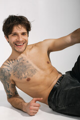 Fototapeta premium Emotional portrait of a handsome guy with an athletic figure 