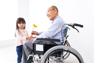 おじいちゃんにお花を渡す女の子