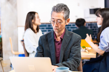 カフェで仕事をする中年男性