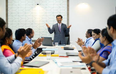 Confident company executive speaking at board meeting in front of employees - concept of team...
