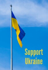 SUPPORT UKRAINE text on Ukrainian national flag flutters in the wind against the blue sky. National...
