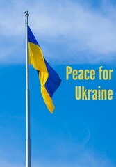 PEACE FOR UKRAINE text on Ukrainian national flag flutters in the wind against the blue sky....