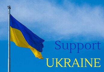SUPPORT UKRAINE text on Ukrainian national flag flutters in the wind against the blue sky. National...