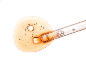 Liquid yellow-orange retinol or vitamin c gel or serum with a dropper on a screen of microscope...