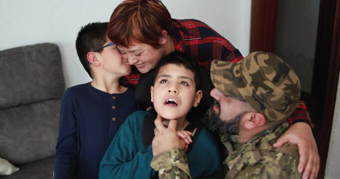 Happy veteran soldier man hugging his family after returning from military service at home - Family moments and war concept