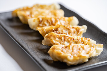 Japanese dumplings or gyoza on black plate, Delicious meal or food background, Nobody	
