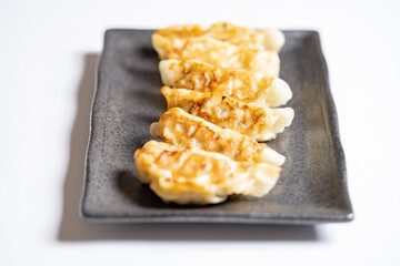 Japanese dumplings or gyoza on black plate, Delicious meal or food background, Nobody	