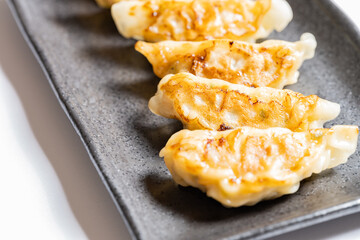 Japanese dumplings or gyoza on black plate, Delicious meal or food background, Nobody	