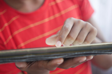 child hand pointing finger on digital tablet screen.