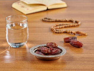 Ramadan date water and turkish style zinc silver plate, rosary style on the wooden table.