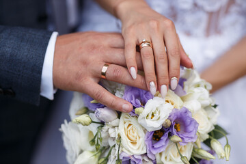 hand of a man of the bridegroom and the girl of the bride with gold wedding rings close-up on a...