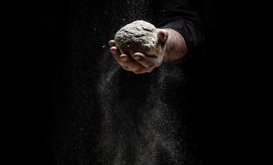 the chef sprinkles flour through a sieve, Powdery flour flying into air. chef hands with flour in a...