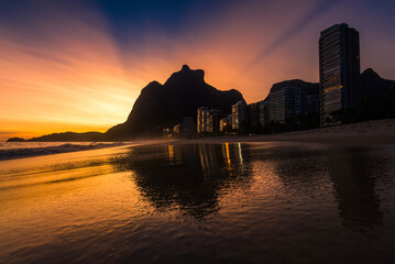 Warm Sunset at Empty Sao Conrado Beach in Rio de Janeiro With Luxury Apartment Buildings and Pedra da Gavea View Reflected on Wet Sand