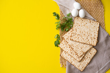 Banner. Layout of  Traditional Matzah prepared for Passover with eggs and parsley on yellow background. top view. Spring Holiday of Jewish people. Fasting time. Space for text.