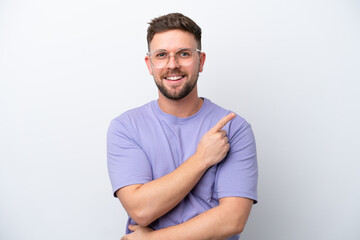 Fototapeta premium Young caucasian man isolated on white background pointing to the side to present a product