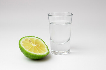 tequila shot with lime isolated on white
