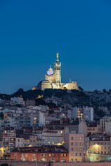 The Old Port and Basilica of Notre Dame de la Garde at dusk in Marseille, France