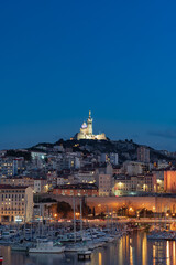The Old Port and Basilica of Notre Dame de la Garde at dusk in Marseille, France