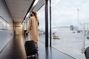 Woman at the airport. Boarding. Walking with suitcase at the airport.