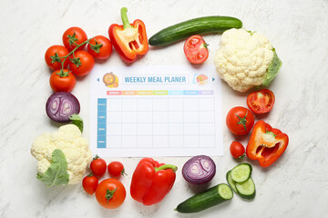 Weekly meal planner and different healthy products on light background