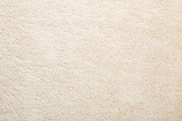 Fototapety  Beige new fluffy home carpet background. Closeup. Empty place for text. Top down view.