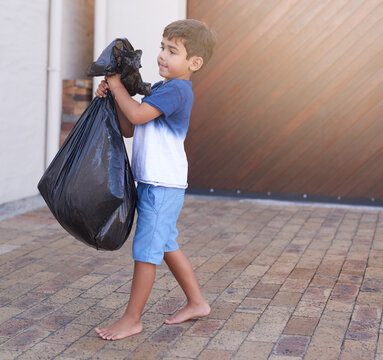 Time to take out the trash. Shot of a little boy taking out the trash at home.