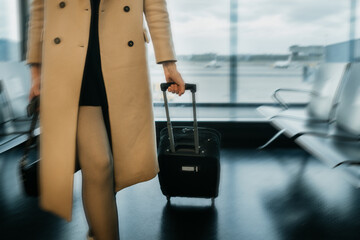 Midsection.Traveler woman walking with suitcase at the airport. Boarding