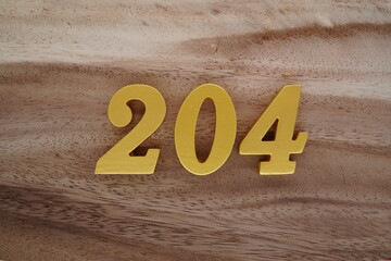 Golden Arabic numerals on a real brown and white wooden floor number 204