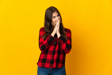 Teenager Brazilian girl isolated on yellow background keeps palm together. Person asks for something