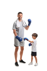 Little boy with and his boxing trainer on white background