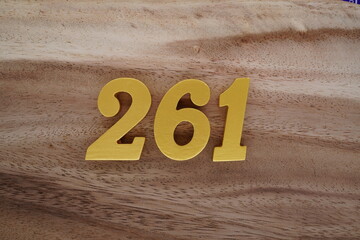 Golden Arabic numerals on a real brown and white wooden floor number 261.