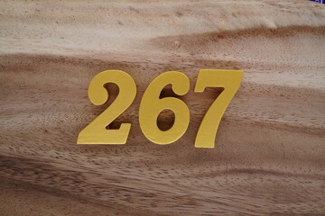 Golden Arabic numerals on a real brown and white wooden floor number 267