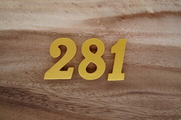Golden Arabic numerals on a real brown and white wooden floor number 281