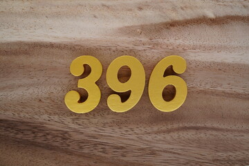 Golden Arabic numerals on a real brown and white wooden floor number 396