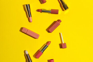 Set of different lipsticks on yellow background