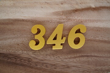 Golden Arabic numerals on a real brown and white wooden floor number 346
