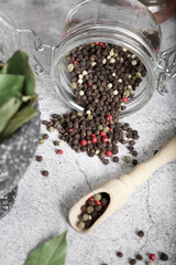 Seasoning for food, spices, flavor additive. Peppercorns black white red scattered in a glass jar