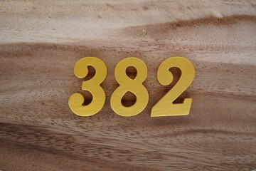 Golden Arabic numerals on a real brown and white wooden floor number 328