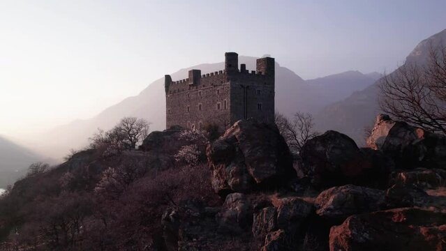 Revealing the Ussel Castle in Valle d&rsquo;Aosta from behind the rocks, aerial view.