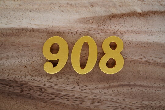 Golden Arabic numerals on a real brown and white wooden floor number 908