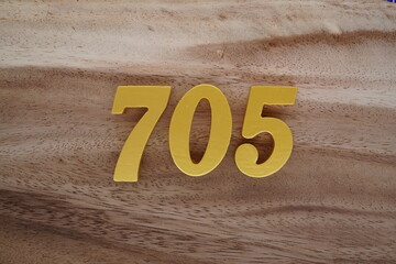 Golden Arabic numerals on a real brown and white wooden floor number 705