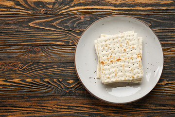 Plate with Jewish flatbread for Passover on wooden background