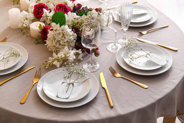 Stylish table setting with wedding invitation and gypsophila flowers
