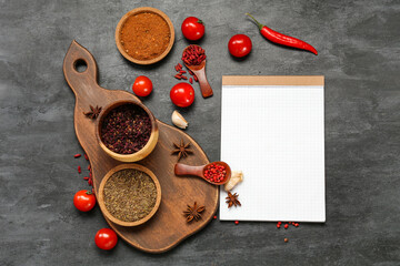 Composition with spices, vegetables and blank notebook on dark background