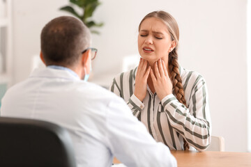 Ill woman with sore throat visiting doctor in clinic
