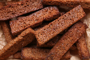 Tasty rye croutons on table, closeup