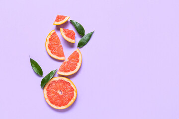 Fresh grapefruit slices on purple background