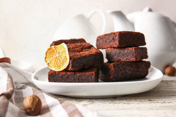 Plate with pieces of delicious chocolate brownie on table