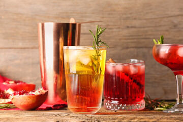 Glasses of tasty pomegranate cocktail on wooden background