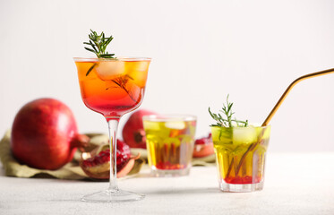 Glasses of tasty pomegranate cocktail on white background